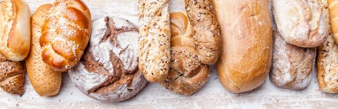 Delicious freshly baked bread on wooden background